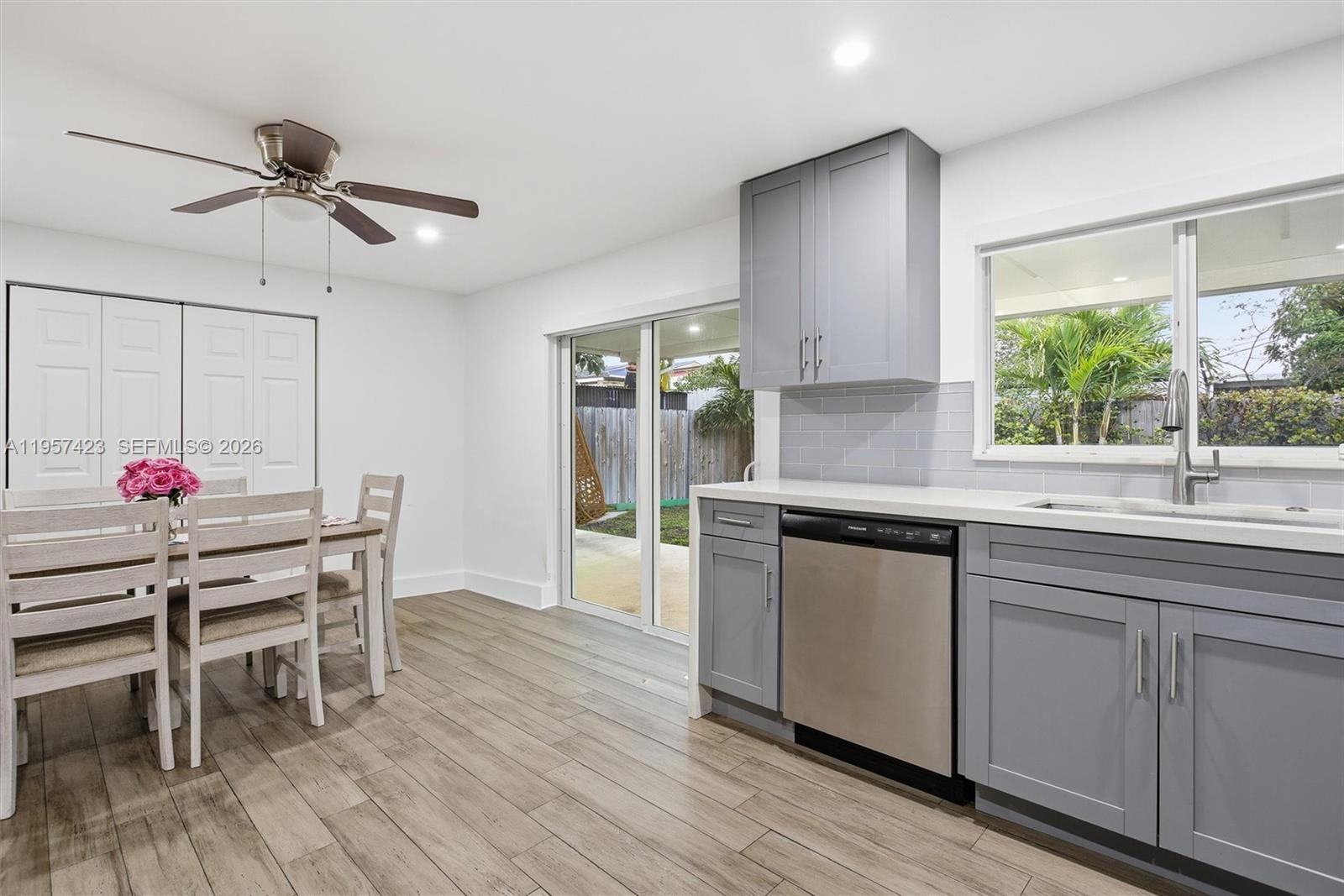 941 East 16th Place Hialeah, FL 33010 - Photo 12 of 32 a kitchen with stainless steel appliances granite countertop wooden floors and white cabinets
