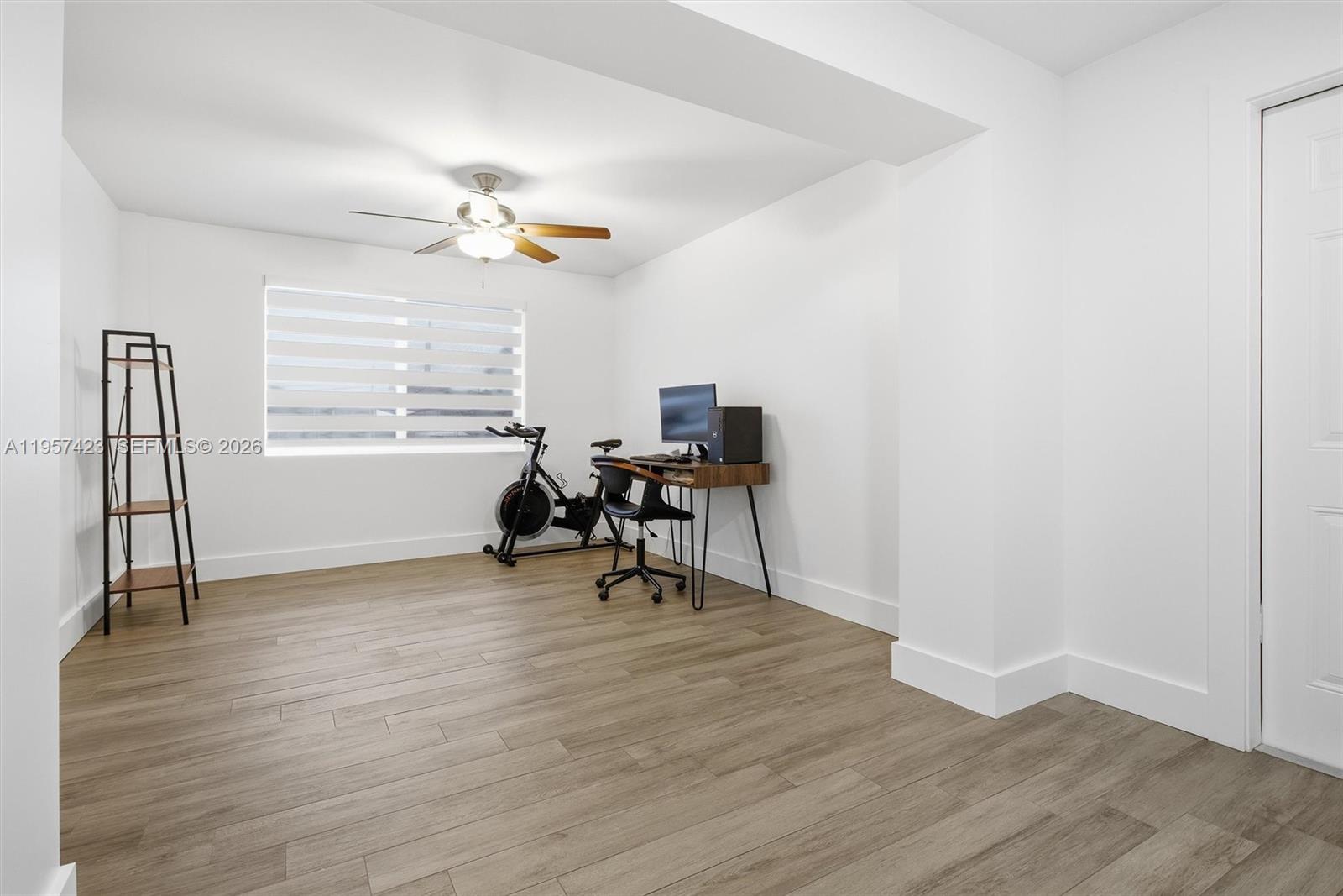 941 East 16th Place Hialeah, FL 33010 - Photo 16 of 32 a view of workspace with wooden floor ceiling fan and windows
