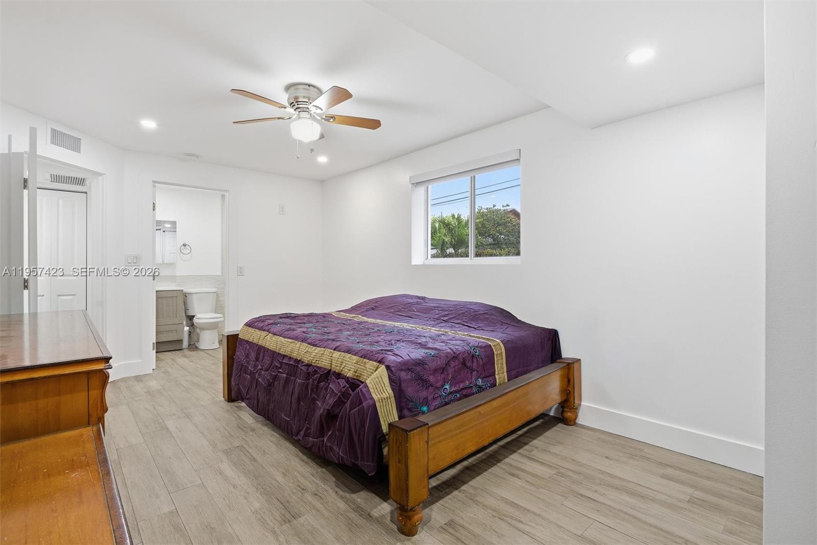 941 East 16th Place Hialeah, FL 33010 - Photo 19 of 32 a spacious bedroom with a bed and a chandelier