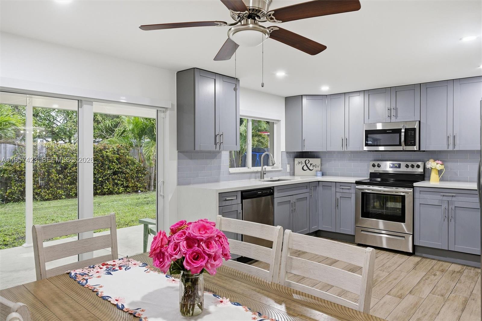941 East 16th Place Hialeah, FL 33010 - Photo 9 of 32 a kitchen with kitchen island granite countertop a stove a sink and dishwasher wooden cabinets with granite countertops