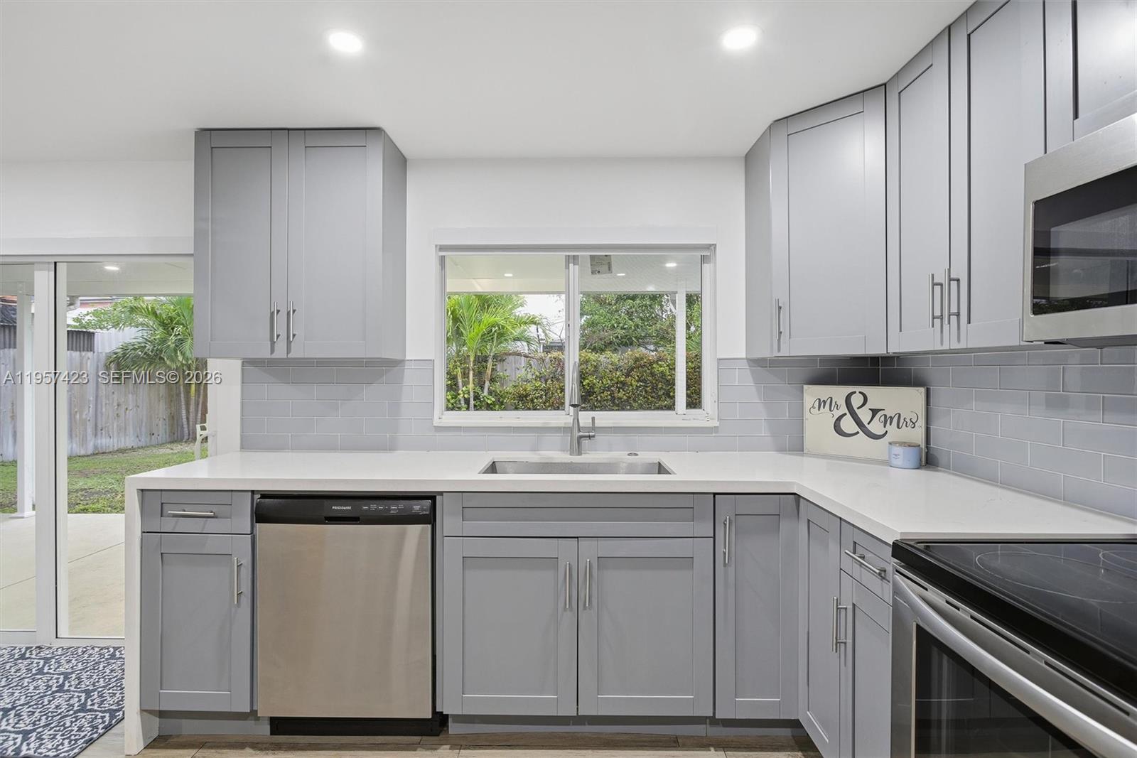 941 East 16th Place Hialeah, FL 33010 - Photo 10 of 32 a kitchen with cabinets appliances a sink and a window