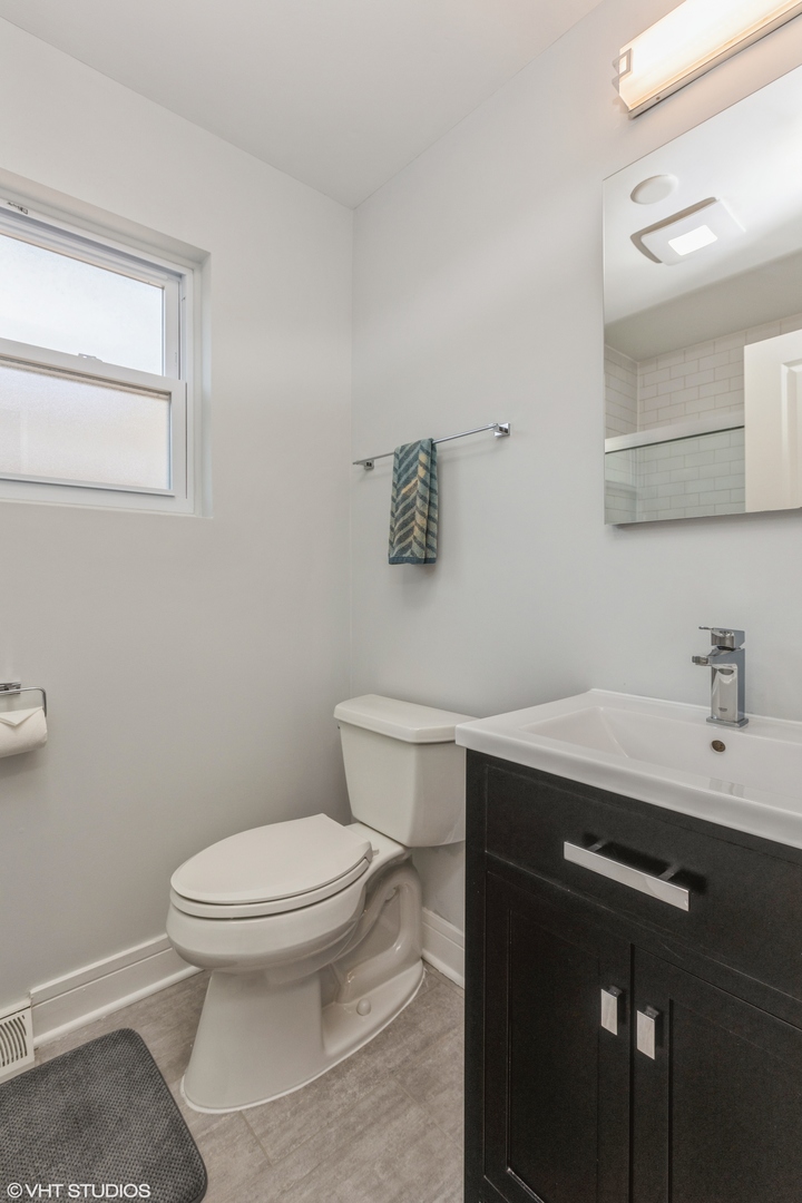 4150 Main Street Skokie, IL 60076 - Photo 16 of 28 a bathroom with a toilet a sink and mirror