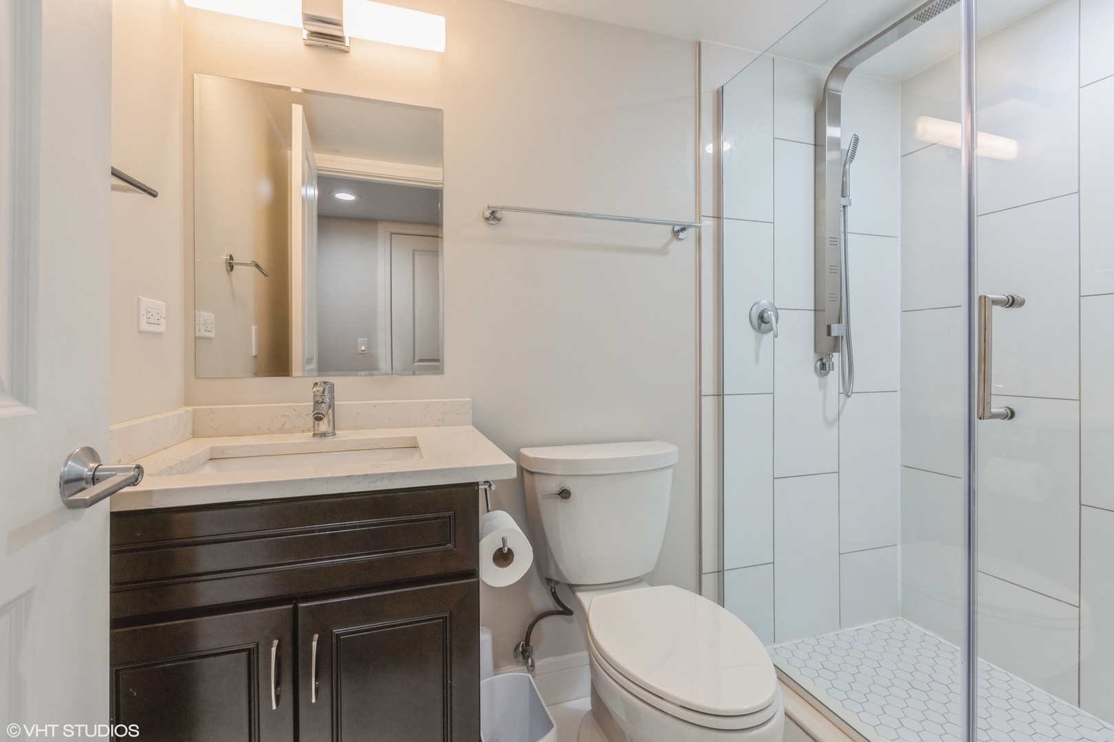 4150 Main Street Skokie, IL 60076 - Photo 21 of 28 a bathroom with a sink a toilet a mirror and shower