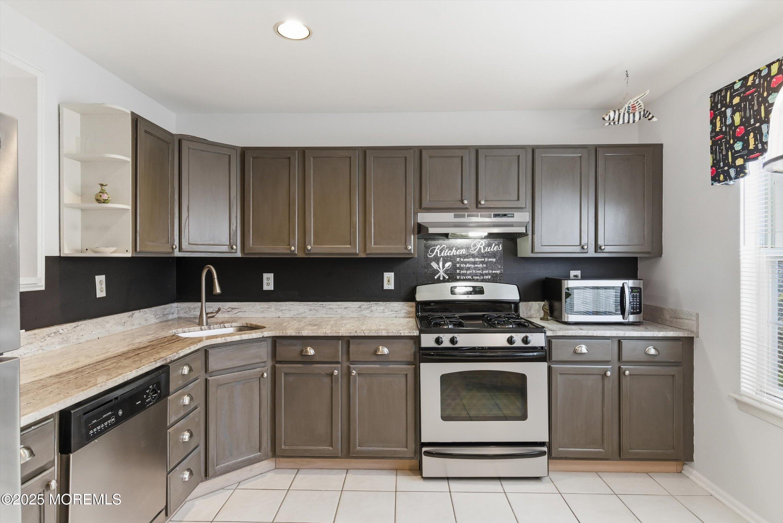 59 Perri Road Freehold, NJ 07728 - Photo 12 of 36 a kitchen with a stove sink and cabinets