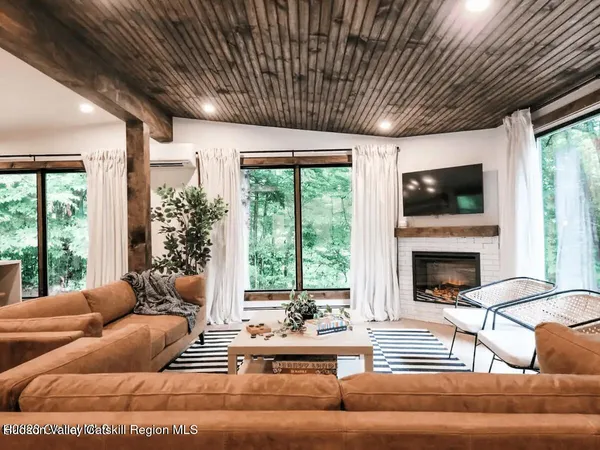 a living room with furniture a fireplace and a large window