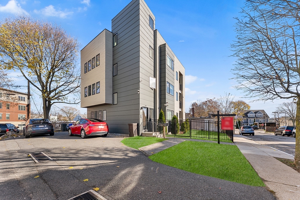 108 Maywood Street, Unit 2 Boston, MA 02119 - Photo 12 of 14 a front view of a building with cars parked