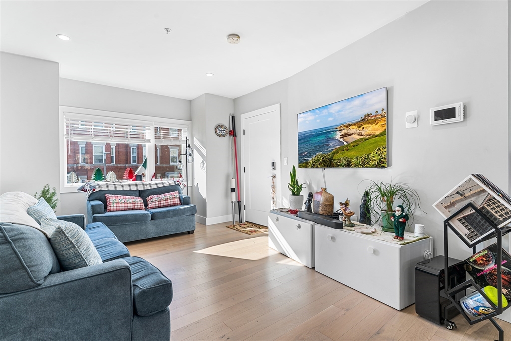 108 Maywood Street, Unit 2 Boston, MA 02119 - Photo 2 of 14 a living room with furniture and a flat screen tv