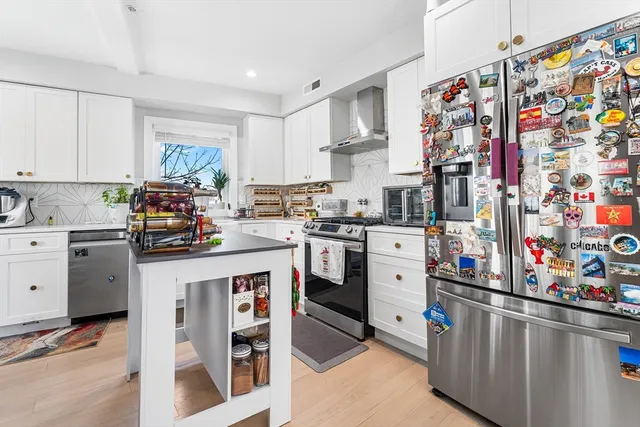 a kitchen with stainless steel appliances and white cabinets