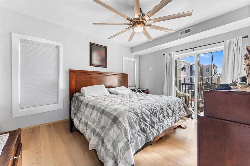 108 Maywood Street, Unit 2 Boston, MA 02119 - Photo 7 of 14 a bedroom with a large bed and a chandelier