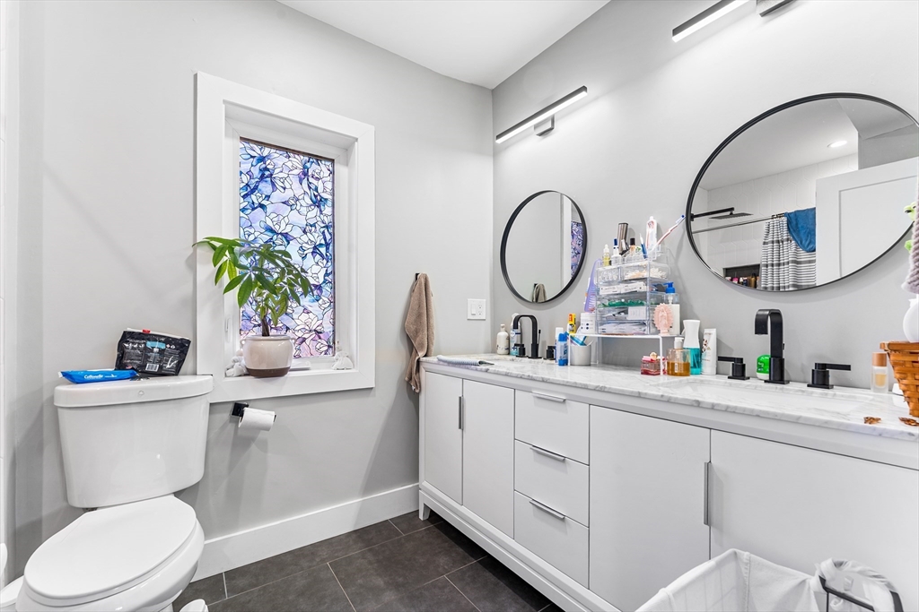 108 Maywood Street, Unit 2 Boston, MA 02119 - Photo 9 of 14 a bathroom with a toilet a sink and a mirror
