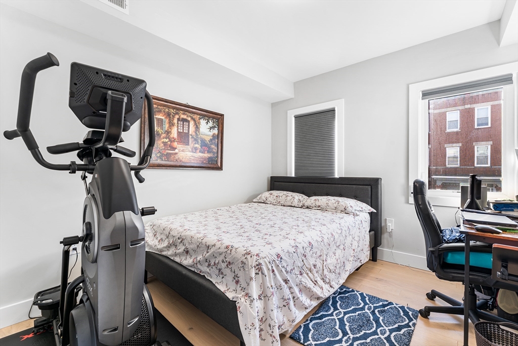 108 Maywood Street, Unit 2 Boston, MA 02119 - Photo 10 of 14 a bedroom with a bed a desk and chair
