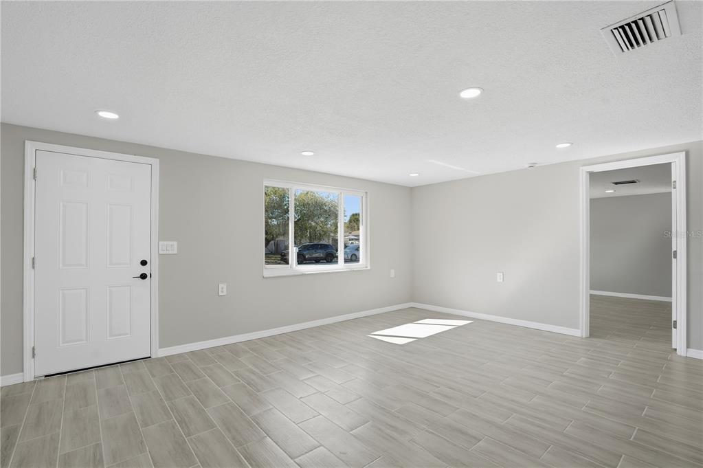 5543 Quist Drive Port Richey, FL 34668 - Photo 12 of 29 an empty room with wooden floor and windows