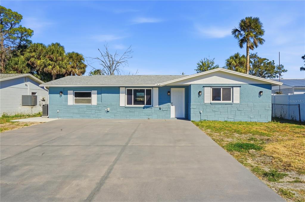 5543 Quist Drive Port Richey, FL 34668 - Photo 21 of 29 a front view of a house with a yard and garage