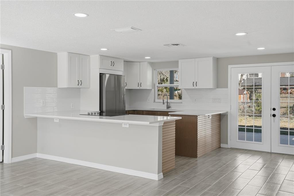 5543 Quist Drive Port Richey, FL 34668 - Photo 8 of 29 a kitchen with stainless steel appliances granite countertop a stove a sink and a refrigerator