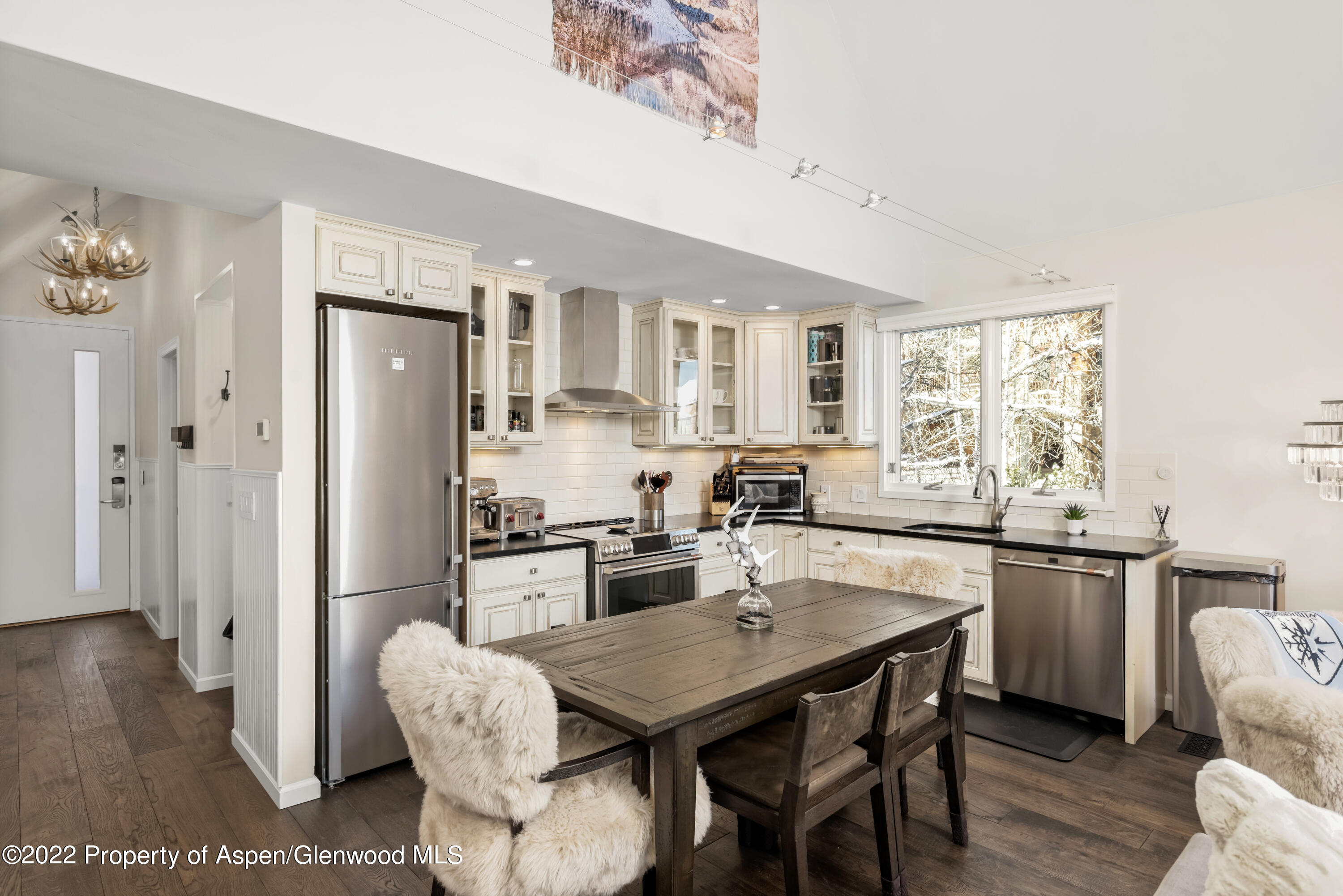 800 South Mill Street, Unit 6A Aspen, CO 81611 - Photo 3 of 18 a kitchen with stainless steel appliances granite countertop a stove a refrigerator a sink a dining table and chairs