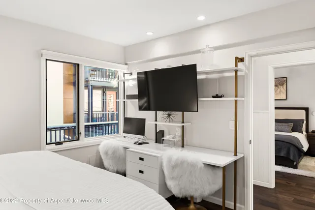 a hotel room with two bed and a flat screen tv