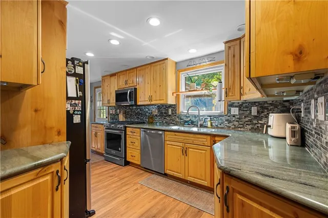 a kitchen with stainless steel appliances granite countertop sink stove top oven and cabinets