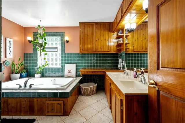 a bathroom with a tub sink and mirror