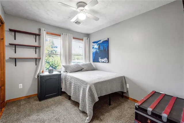 a bedroom with a bed and a ceiling fan