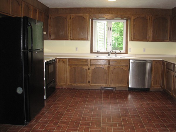 115 Baker Pond Road Dudley, MA 01571 - Photo 7 of 17 a kitchen with granite countertop a refrigerator a stove a sink and dishwasher with wooden floor
