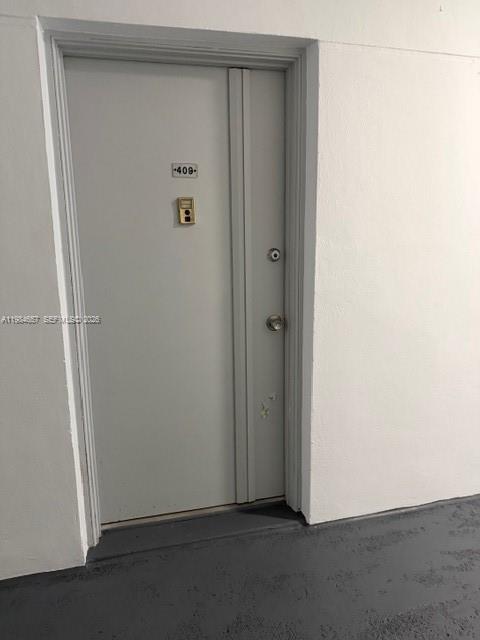 9159 Southwest 77th Avenue, Unit 409 Miami, FL 33156 - Photo 20 of 29 an empty room with wooden door
