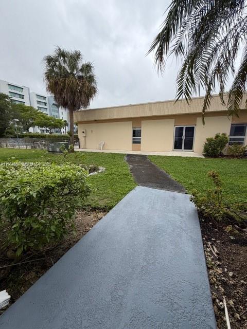9159 Southwest 77th Avenue, Unit 409 Miami, FL 33156 - Photo 26 of 29 a front view of a house with a yard and garage
