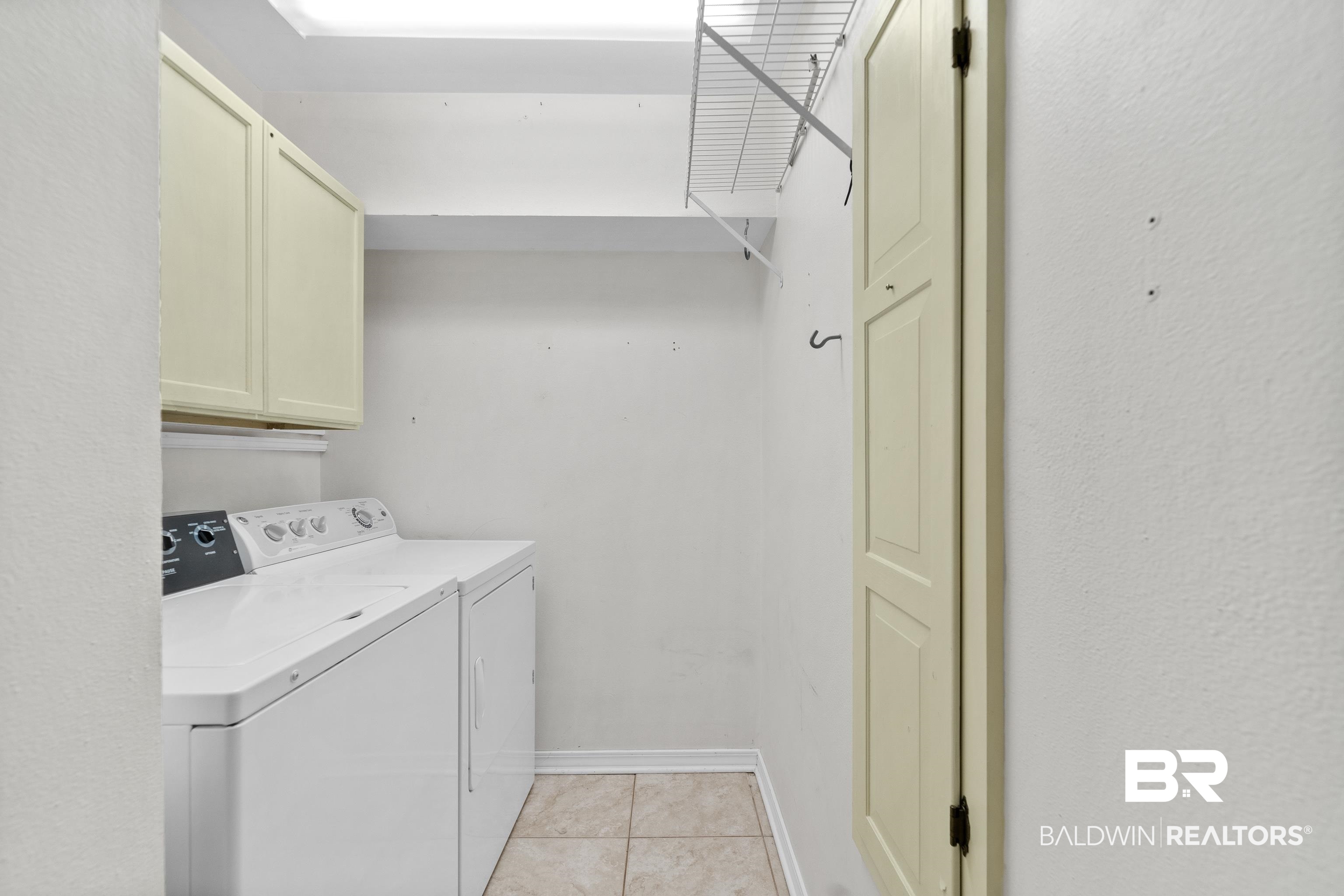 1701 Regency Road, Unit 111 Gulf Shores, AL 36542 - Photo 4 of 29 Laundry area with cabinets, separate washer and dryer, and light tile patterned floors