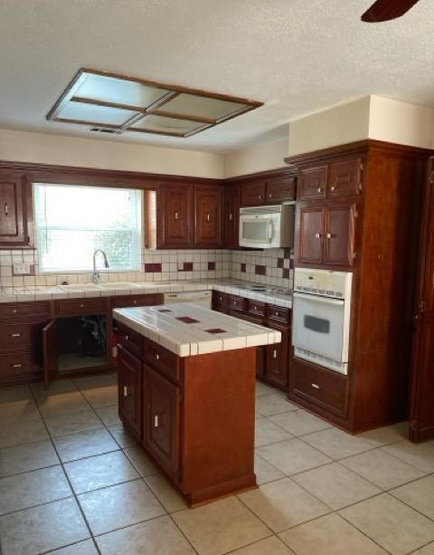47 Devonshire Drive Conroe, TX 77304 - Photo 12 of 27 a kitchen with a stove top oven a sink a counter top space and cabinets