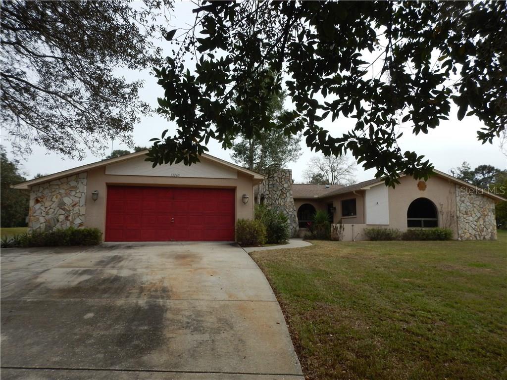 13265 Cooper Road Spring Hill, FL 34609 - Photo 1 of 1 a white house that has a tree in front of it