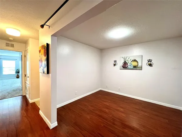 a view of empty room with wooden floor
