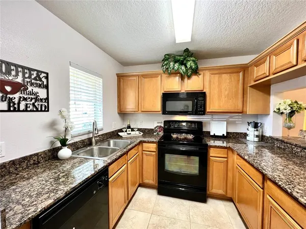 a kitchen with granite countertop stainless steel appliances a stove sink and microwave