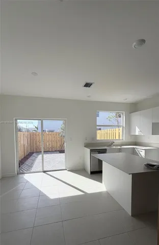 a kitchen with stainless steel appliances granite countertop a sink and white cabinets
