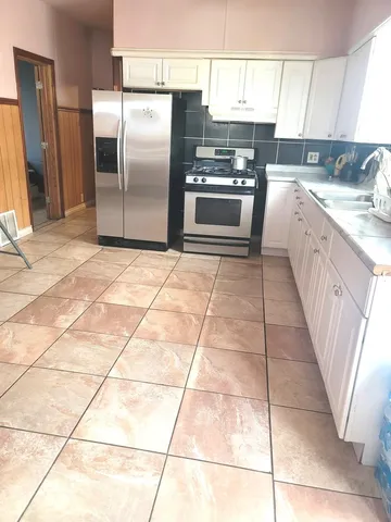 a kitchen with stainless steel appliances granite countertop a refrigerator a sink a stove a microwave and a counter top space