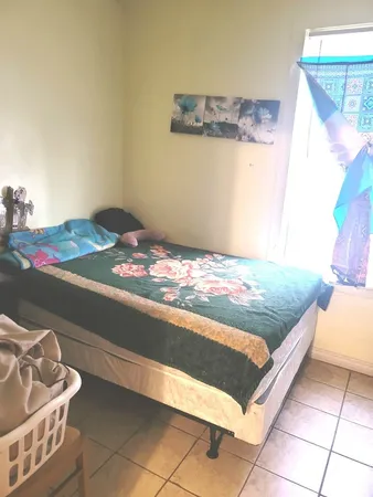 a bed sitting in a bedroom next to a window