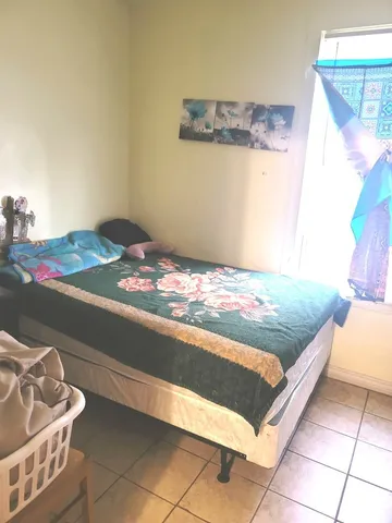 a bed sitting in a bedroom next to a window