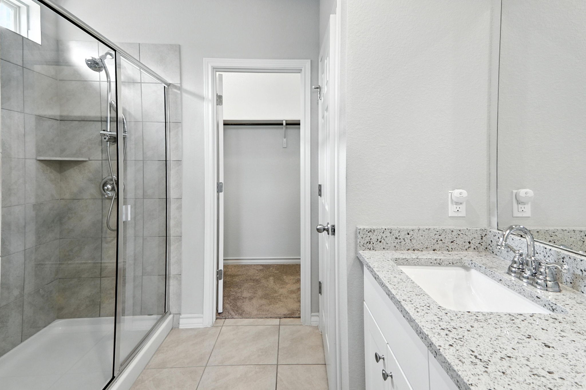 341 Coba Street Leander, TX 78641 - Photo 14 of 28 Bathroom featuring a stall shower, a walk in closet, vanity, and tile patterned floors