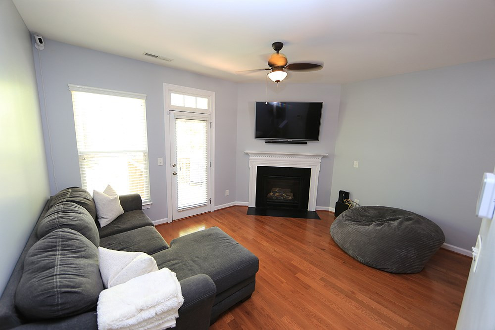 8734 Cypress Grove Run Raleigh, NC 27612 - Photo 12 of 30 The living room features a corner gas fireplace and ceiling fan. Living Room
