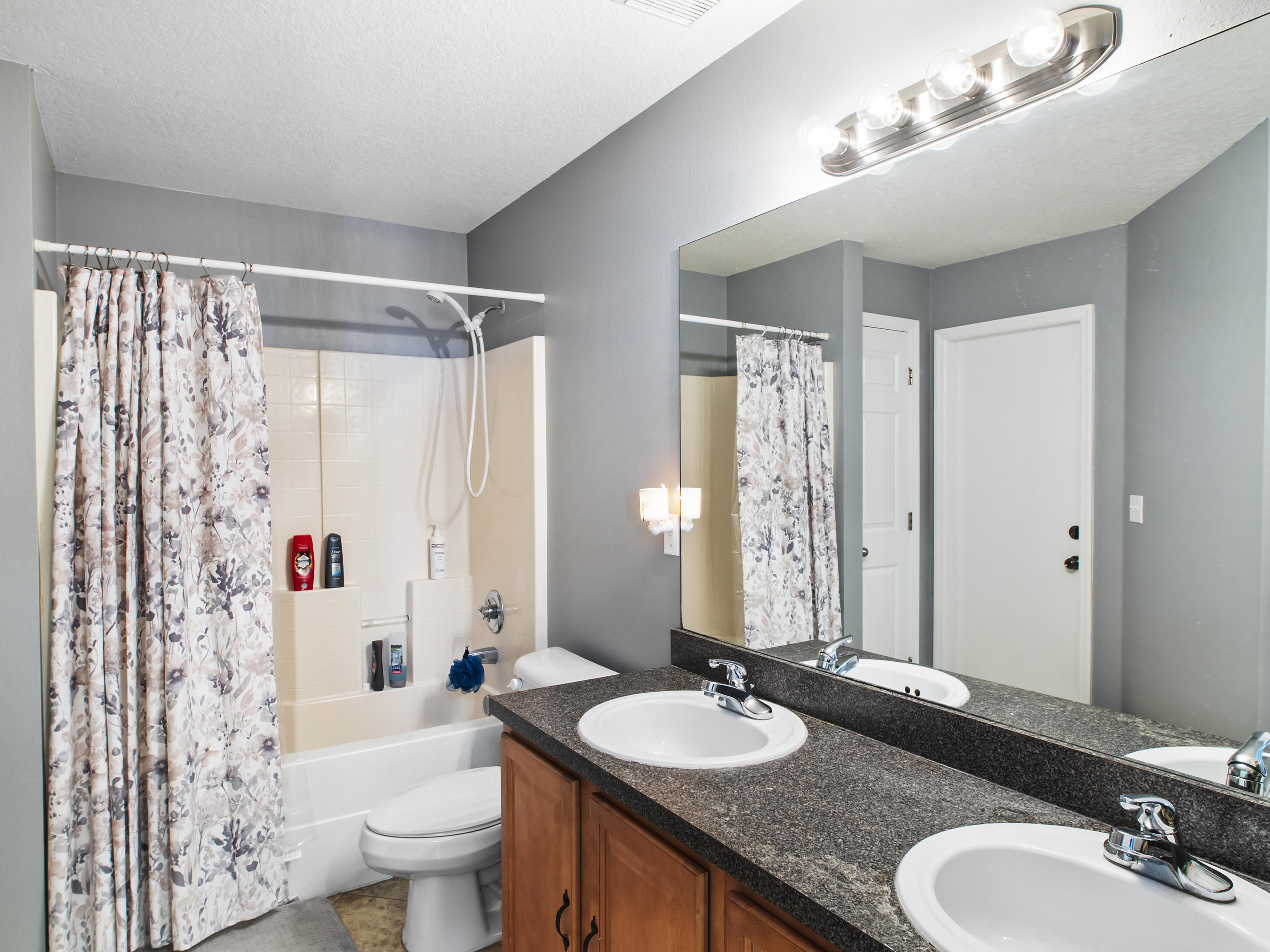 165 Southwest Covington Road Port St. Lucie, FL 34953 - Photo 11 of 26 a bathroom with a granite countertop sink mirror toilet and shower