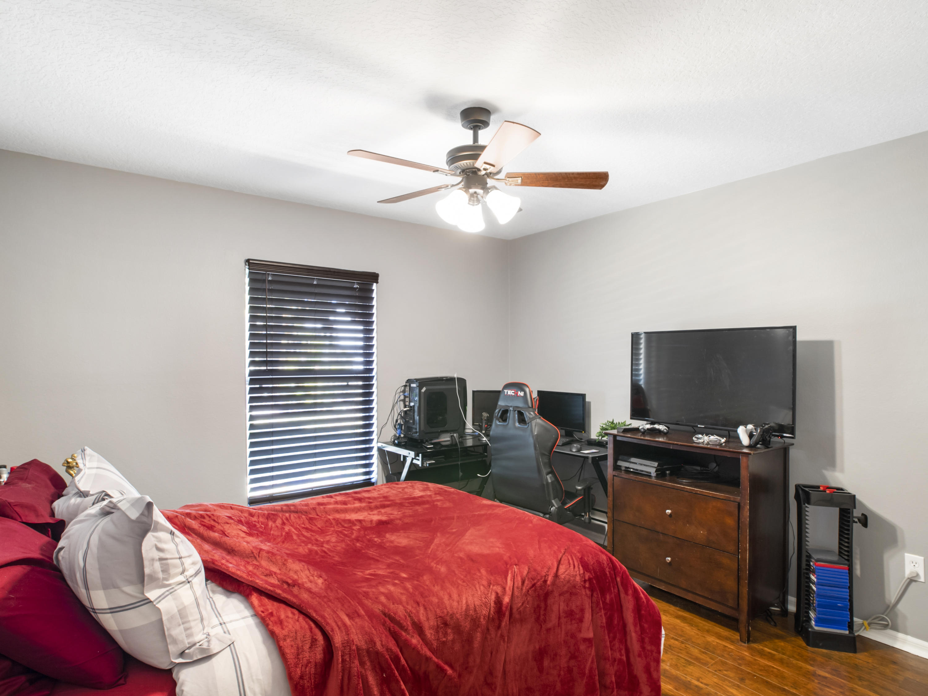 165 Southwest Covington Road Port St. Lucie, FL 34953 - Photo 12 of 26 a bedroom with a bed and a chandelier