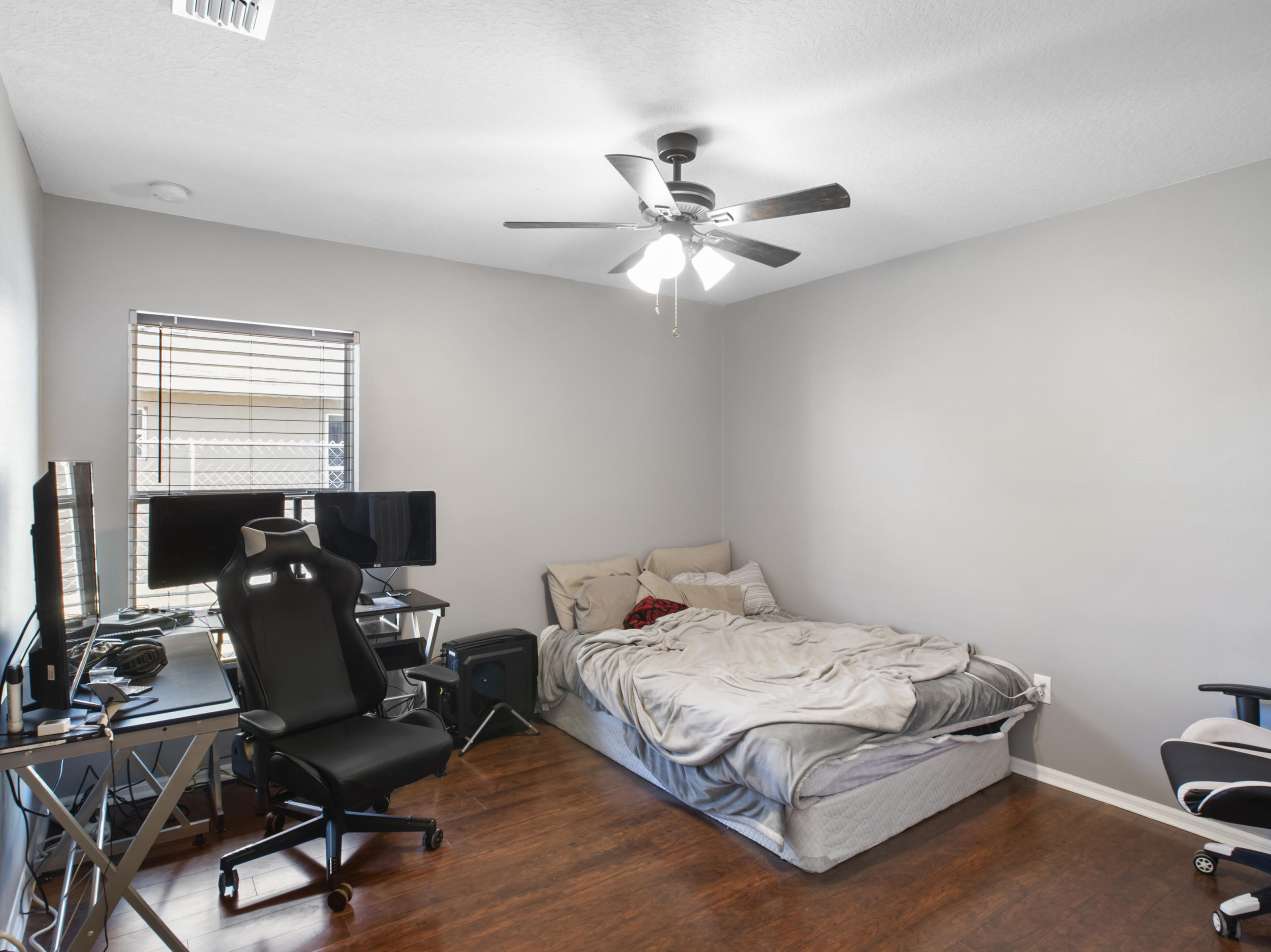 165 Southwest Covington Road Port St. Lucie, FL 34953 - Photo 14 of 26 a bedroom with a bed and a desk
