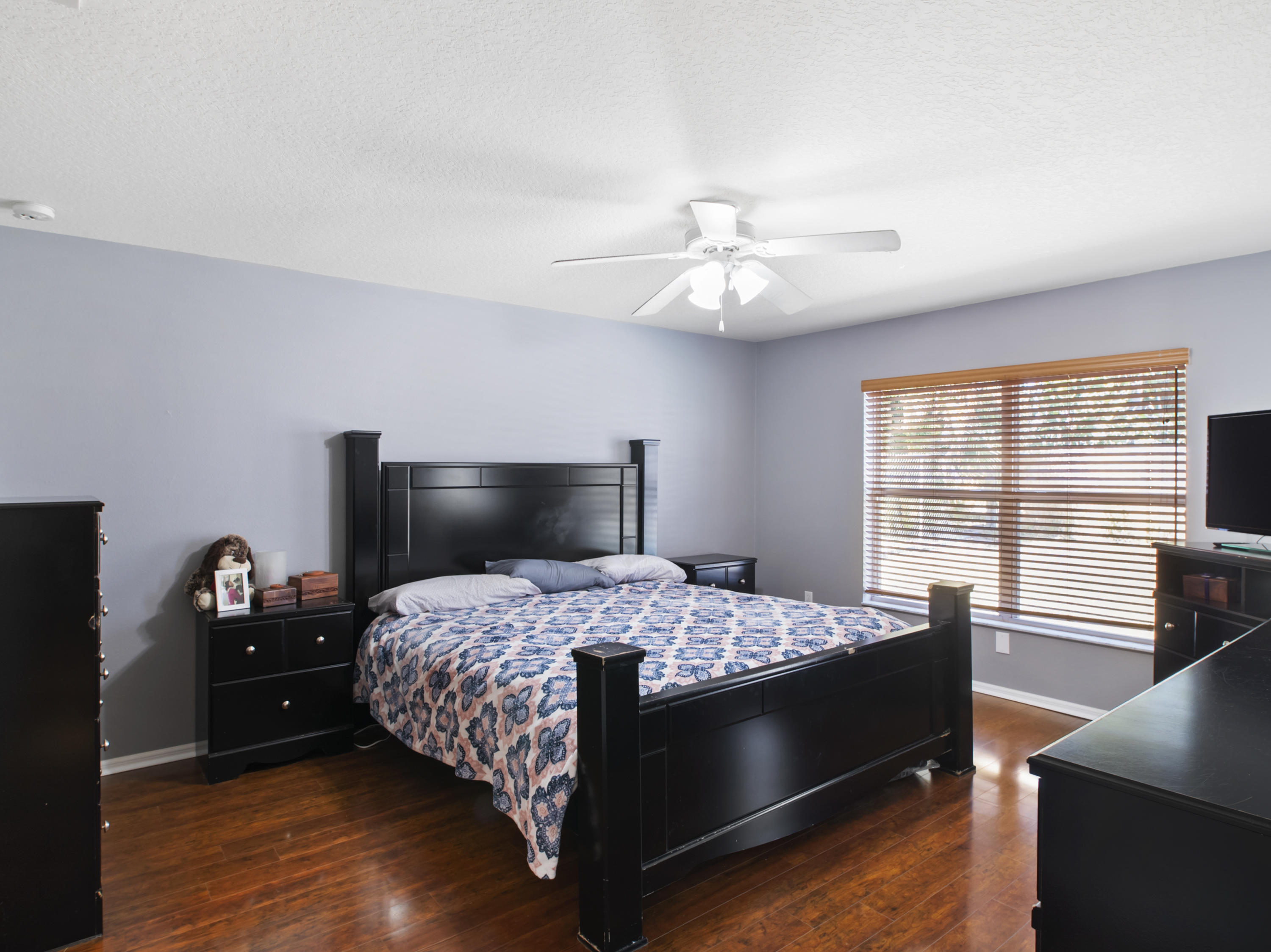 165 Southwest Covington Road Port St. Lucie, FL 34953 - Photo 16 of 26 a bedroom with a bed and a chandelier