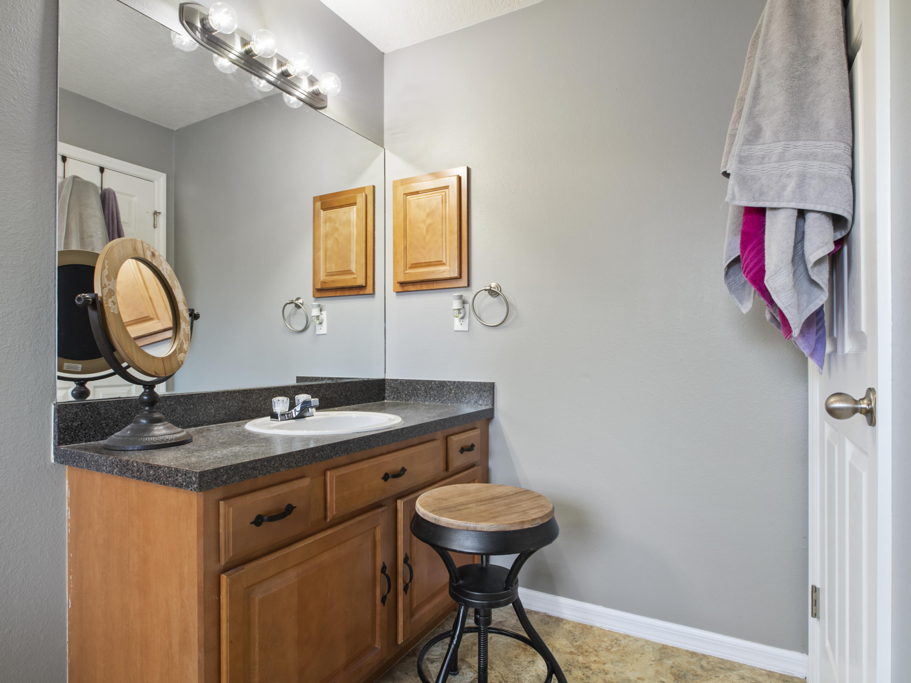 165 Southwest Covington Road Port St. Lucie, FL 34953 - Photo 20 of 26 a bathroom with a granite countertop sink a mirror and a toilet