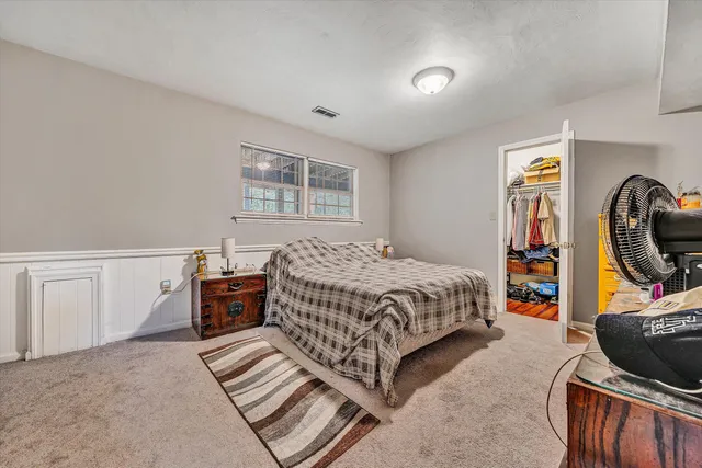 a bedroom with a bed next to a window