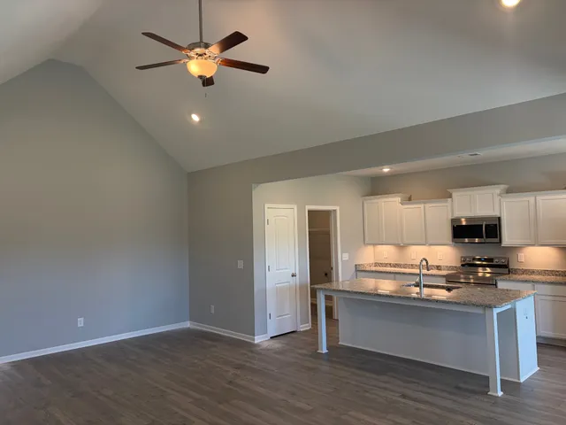 a view of kitchen with granite countertop cabinets and refrigerator