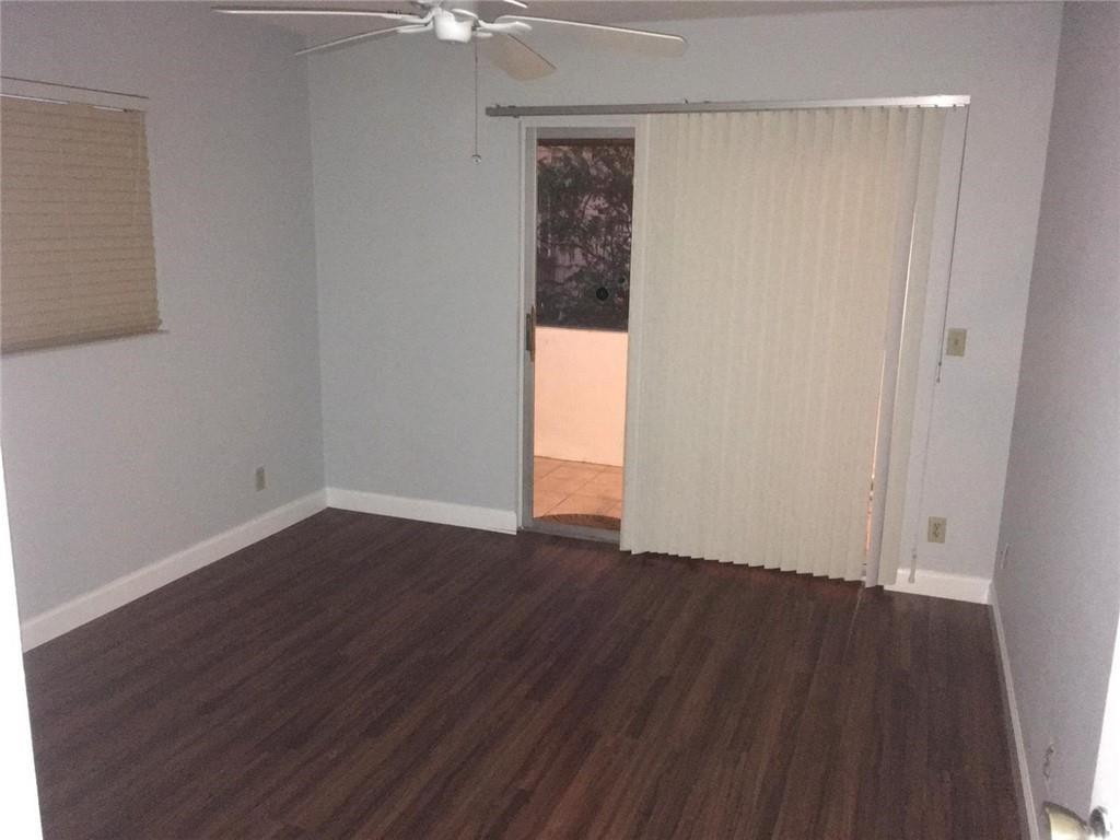 276 Monaco Way Delray Beach, FL 33446 - Photo 6 of 7 an empty room with wooden floor and windows