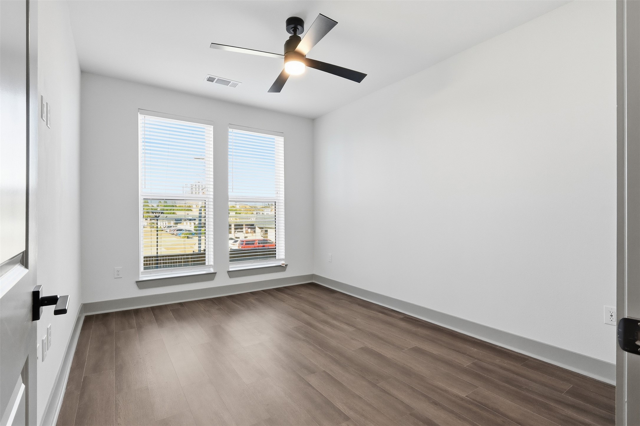1950 Winrock Boulevard, Unit B2 Houston, TX 77057 - Photo 15 of 32 an empty room with wooden floor fan and windows