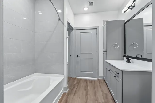 a bathroom with a tub sink and mirror