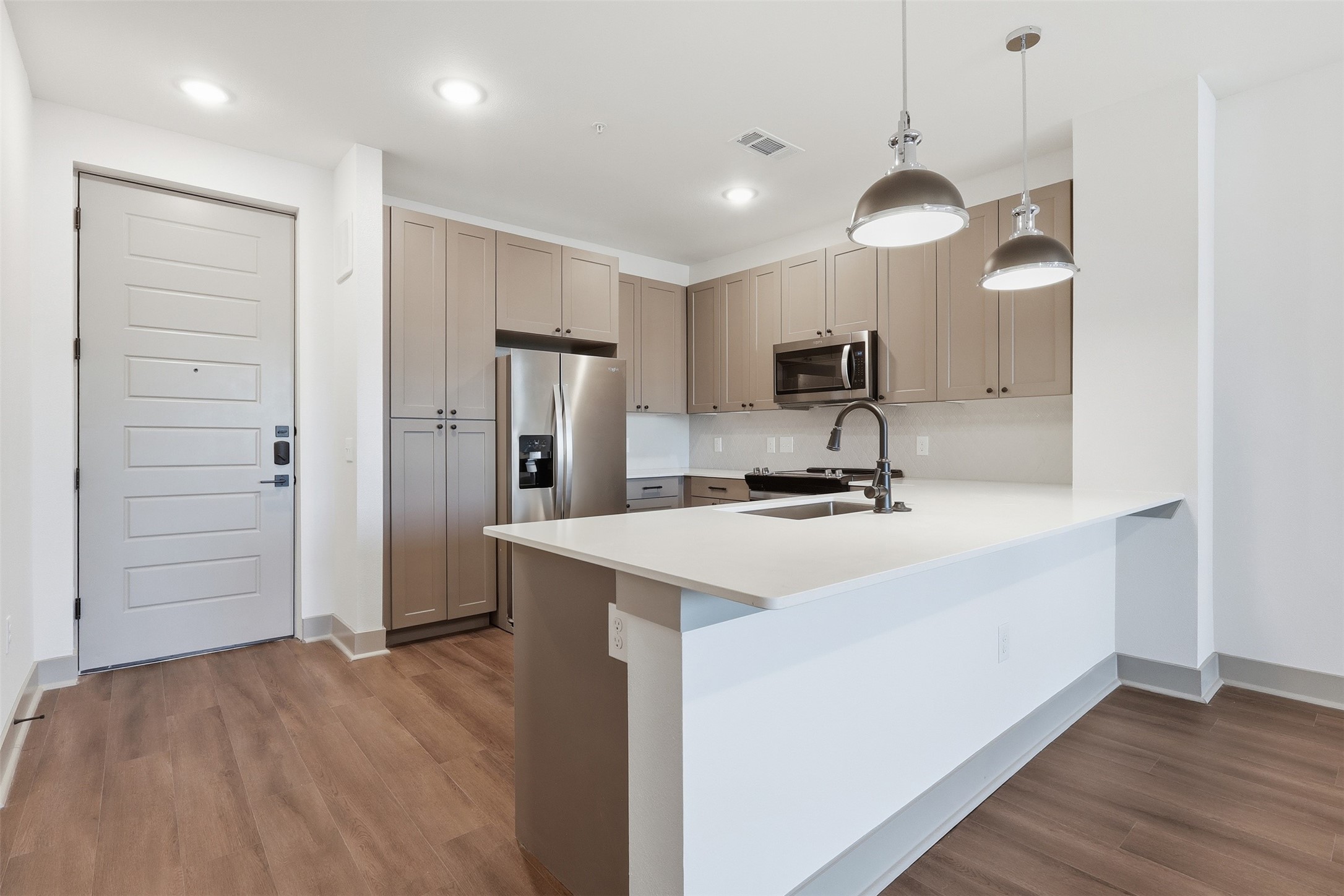 1950 Winrock Boulevard, Unit B2 Houston, TX 77057 - Photo 2 of 32 a kitchen with kitchen island a sink stainless steel appliances and cabinets