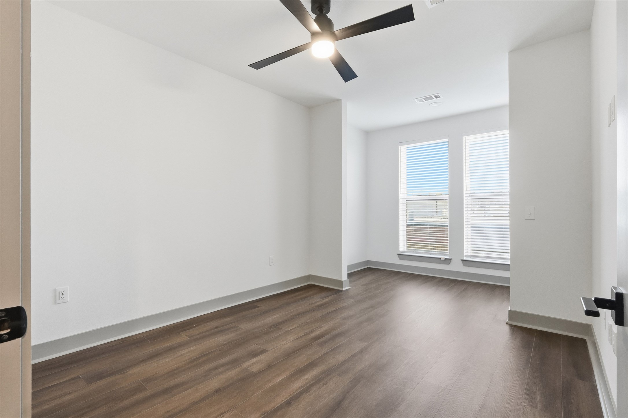 1950 Winrock Boulevard, Unit B2 Houston, TX 77057 - Photo 7 of 32 an empty room with wooden floor fan and windows