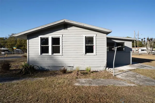 a view of a house with a yard and sitting area